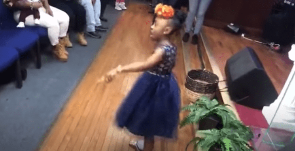 Little girl breaks out powerful praise dance in front of church