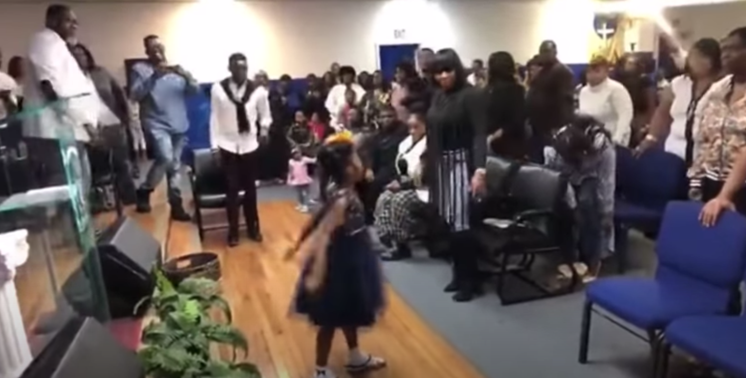 Little girl breaks out powerful praise dance in front of church