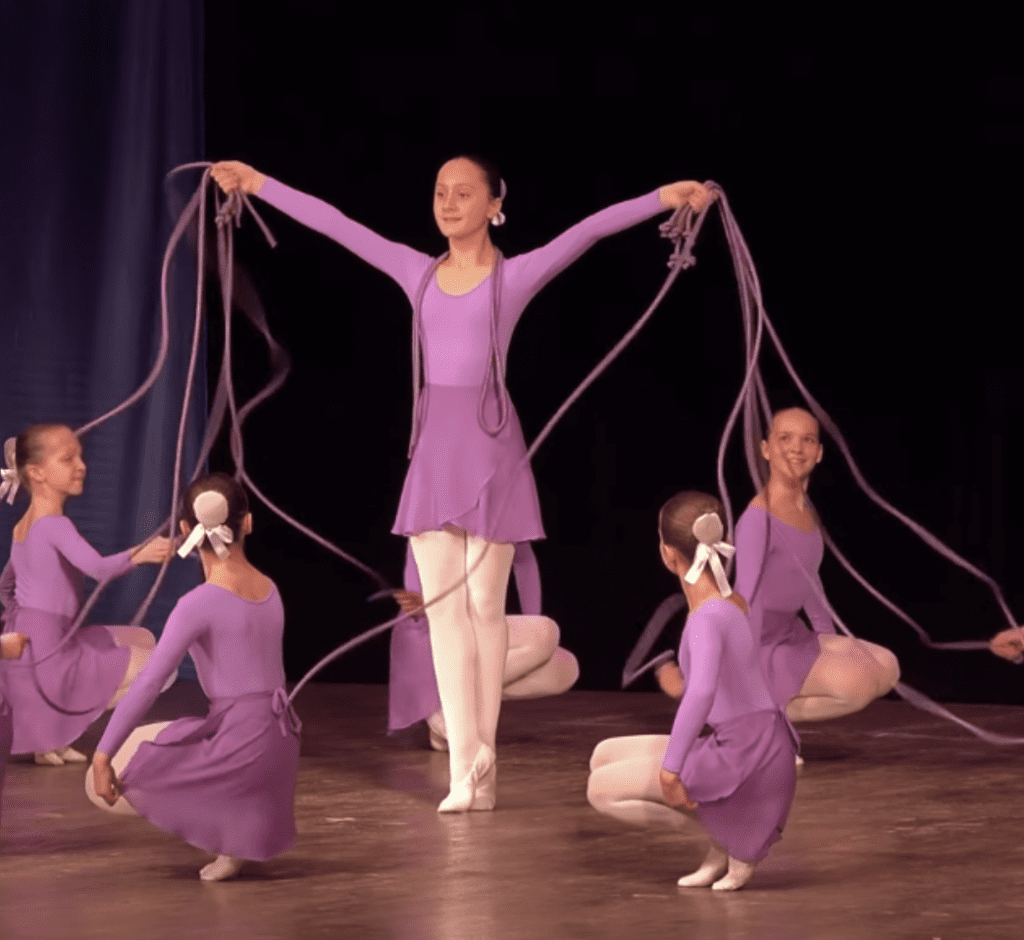 12 young girls perform an intricate dance routine involving…jump ropes?